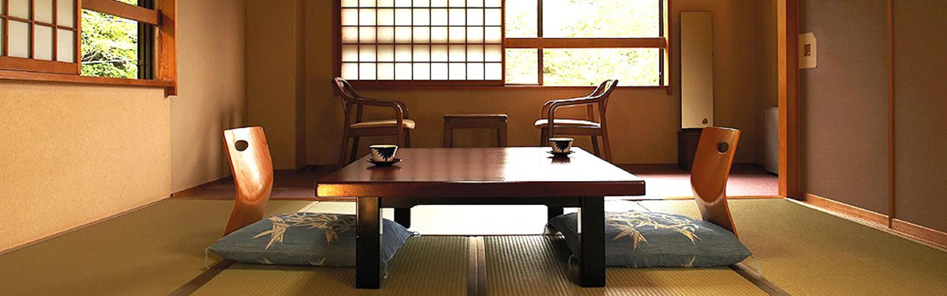 Hakugin no Yu Manzatei with a traditional tatami room with low table and window chairs.