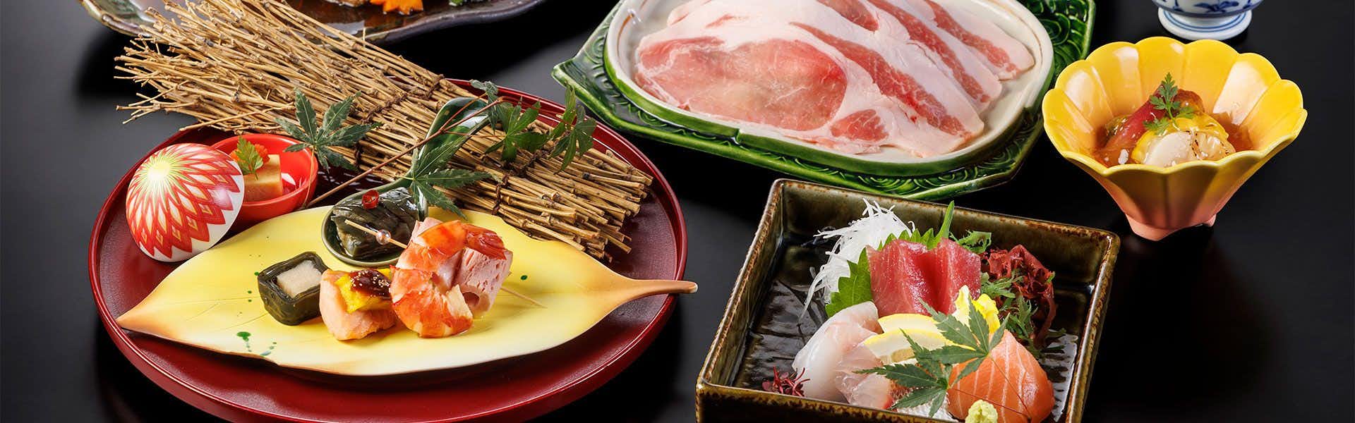 Futatsushima Kanko Hotel with a seasonal dinner featuring sashimi and sliced pork.