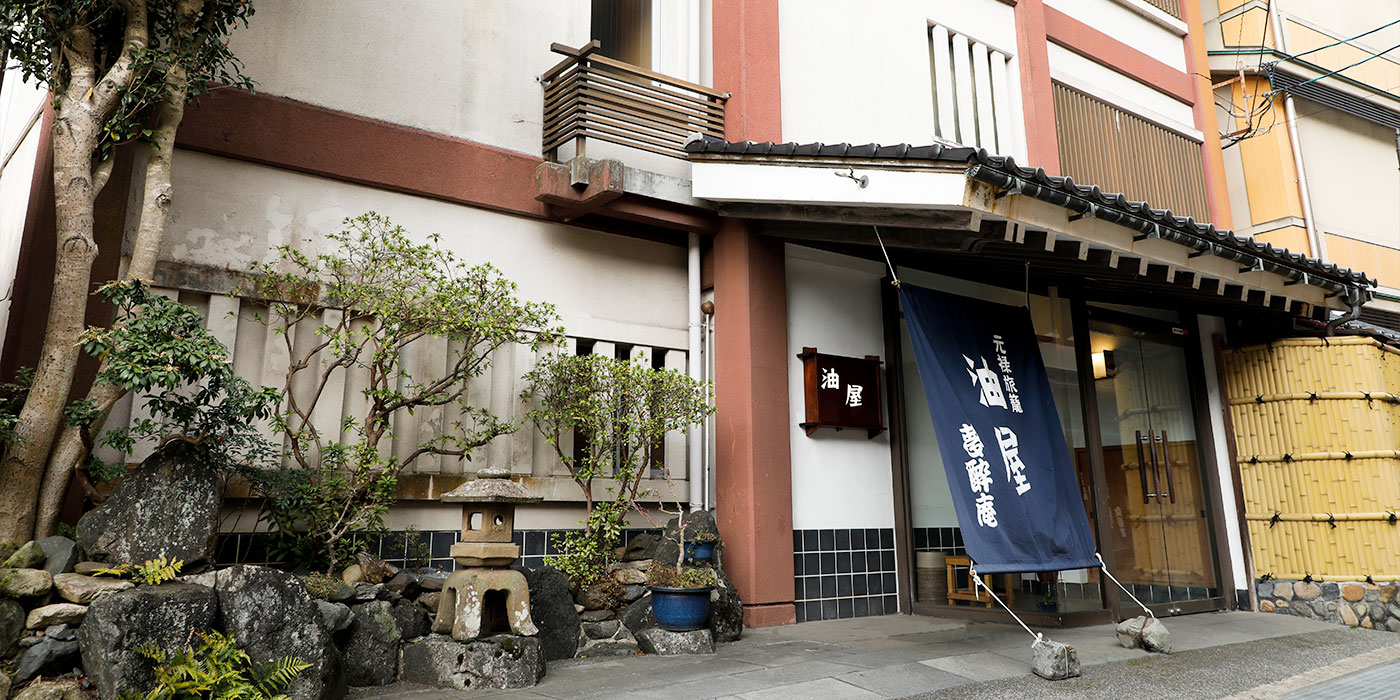 Genroku Hatago Aburaya with this scene, where its lodging entrance is framed by a stone lantern and garden plants.