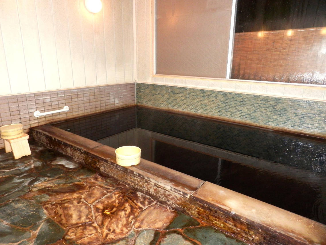 Indoor bath with stone edging.