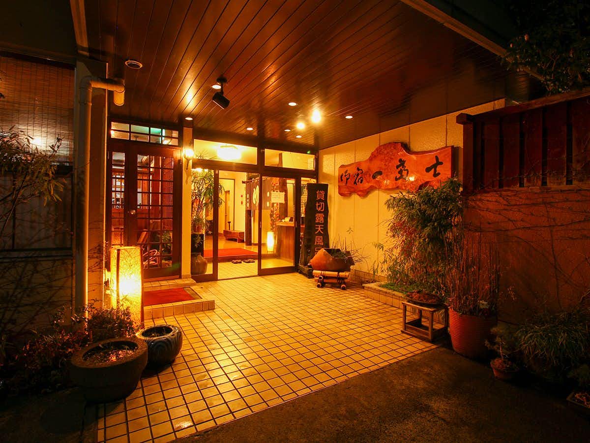 Onyado Ichifuji with the lantern-lit entrance lined with potted plants.