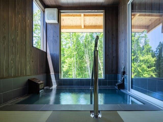 Tazawako Kogen Mizusawa Onsenkyo Ryokan Aoniyama-so with a rectangular private bath surrounded by forest-facing windows.