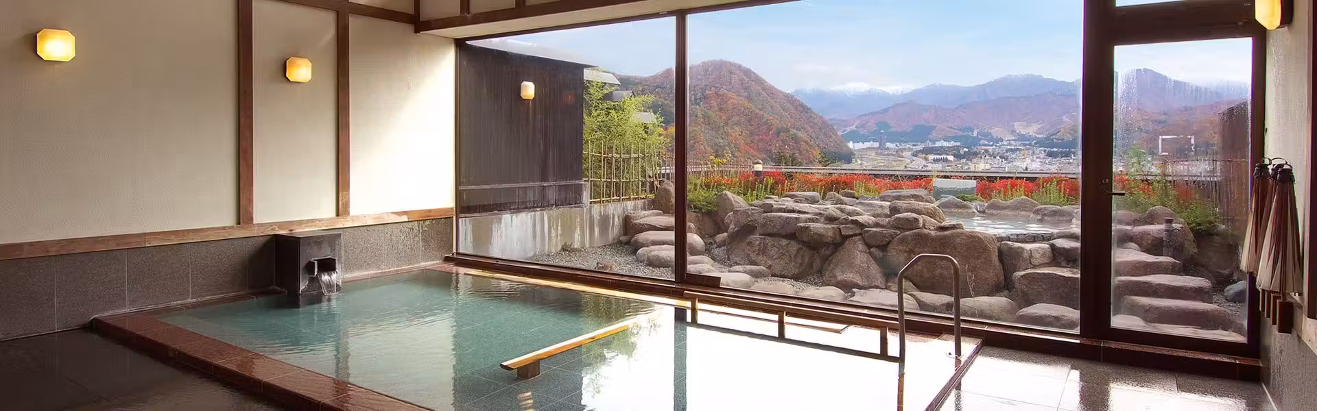 Onyuyado Nakaya with this scene, where a large indoor bath looks across Yuzawa valley through broad windows.