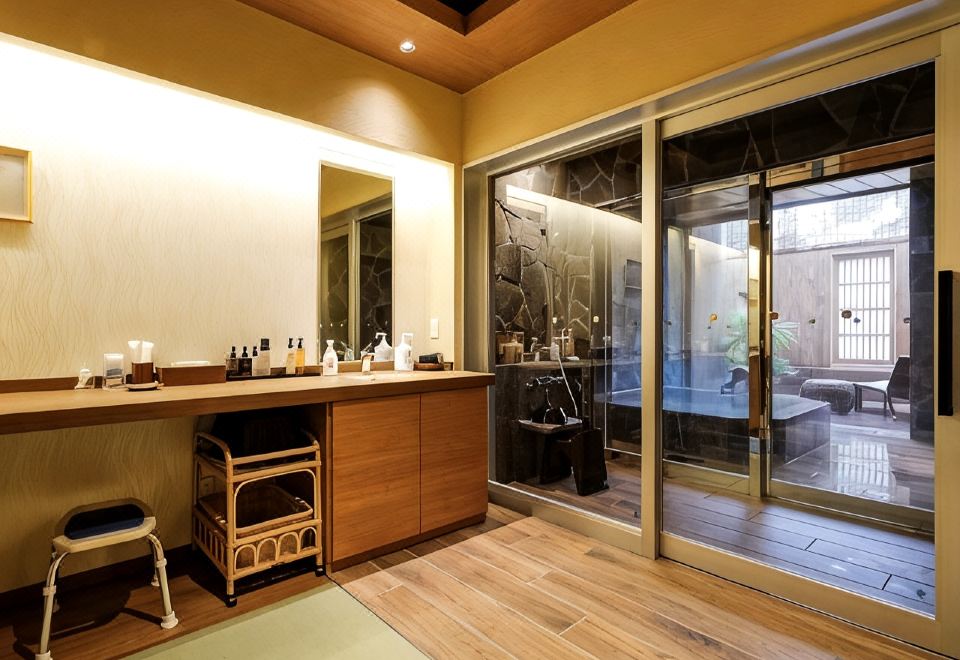 A hotel vanity and bathing area beside a glass door.