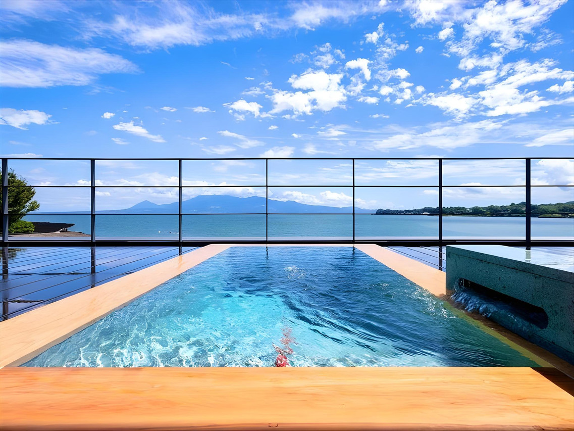 A rooftop pool overlooks blue water and distant islands.