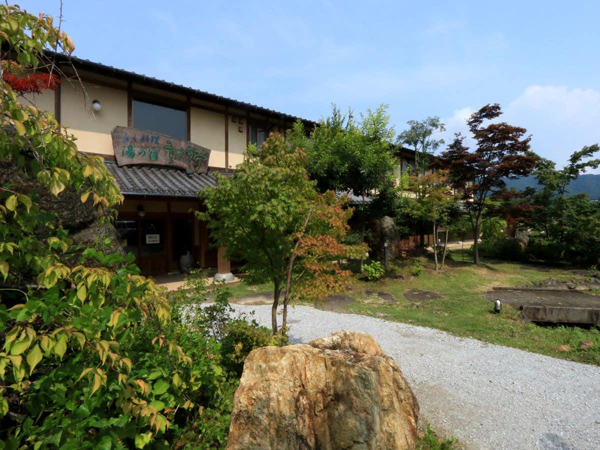 Usuki Yuno Sato garden-facing entrance with a gravel path and large boulders