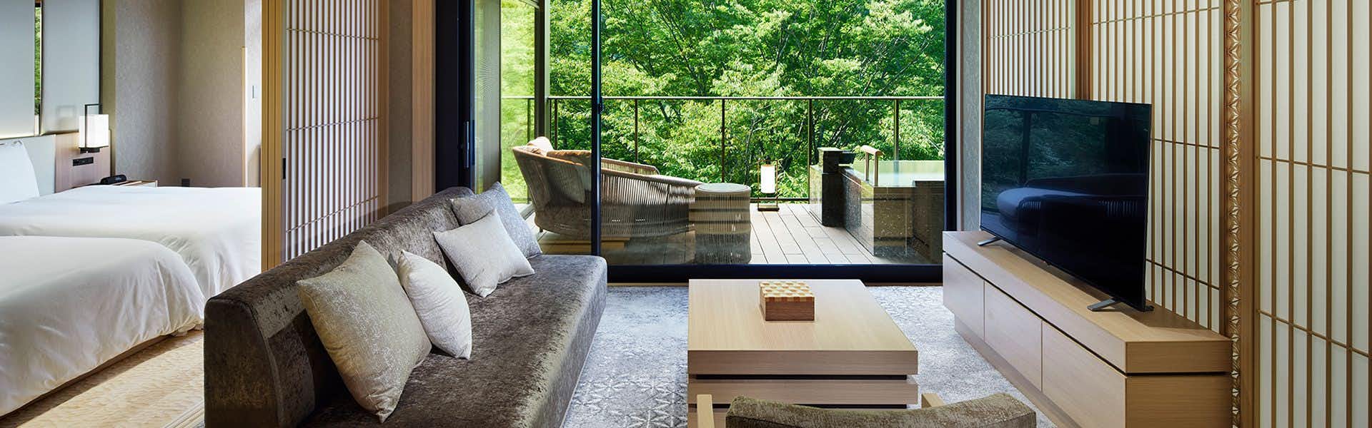 Hatsuhana with a bright suite combining a bed, sofa, and forest terrace.