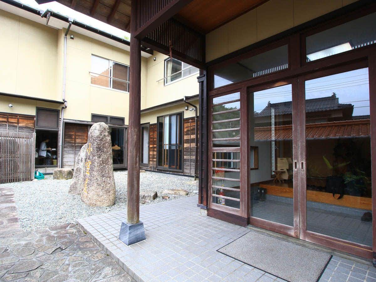 The glass entrance opening onto a small stone courtyard.