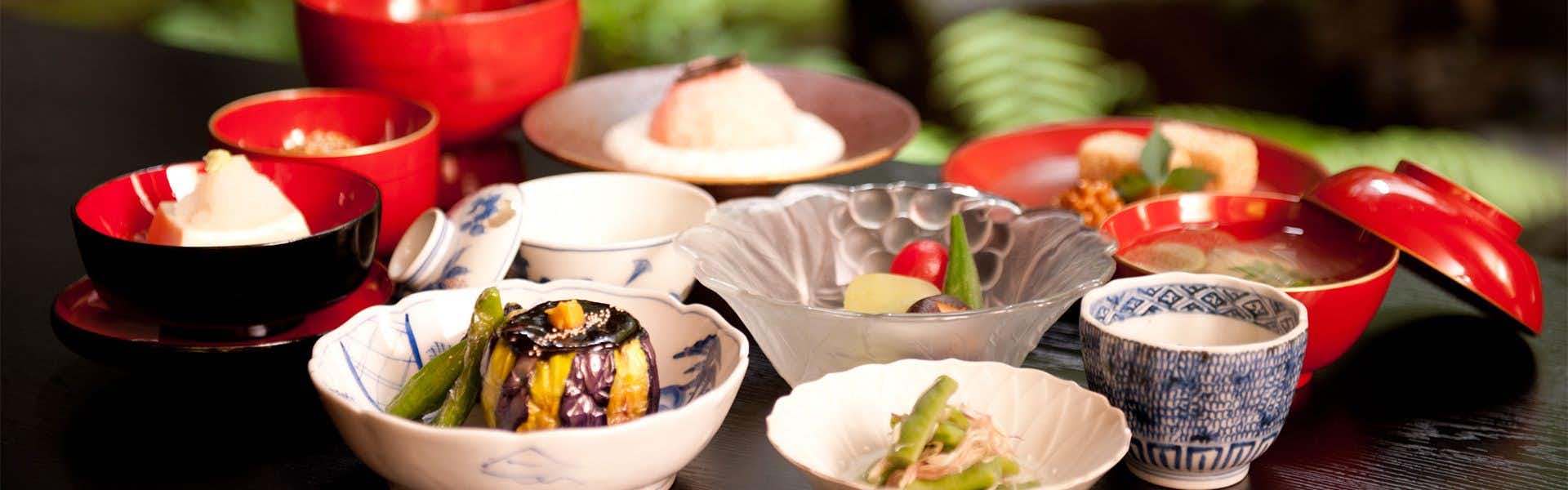 Zenkoji Fuchinobo Ceramic bowls and dishes containing vegetables and prepared food items with various garnishes