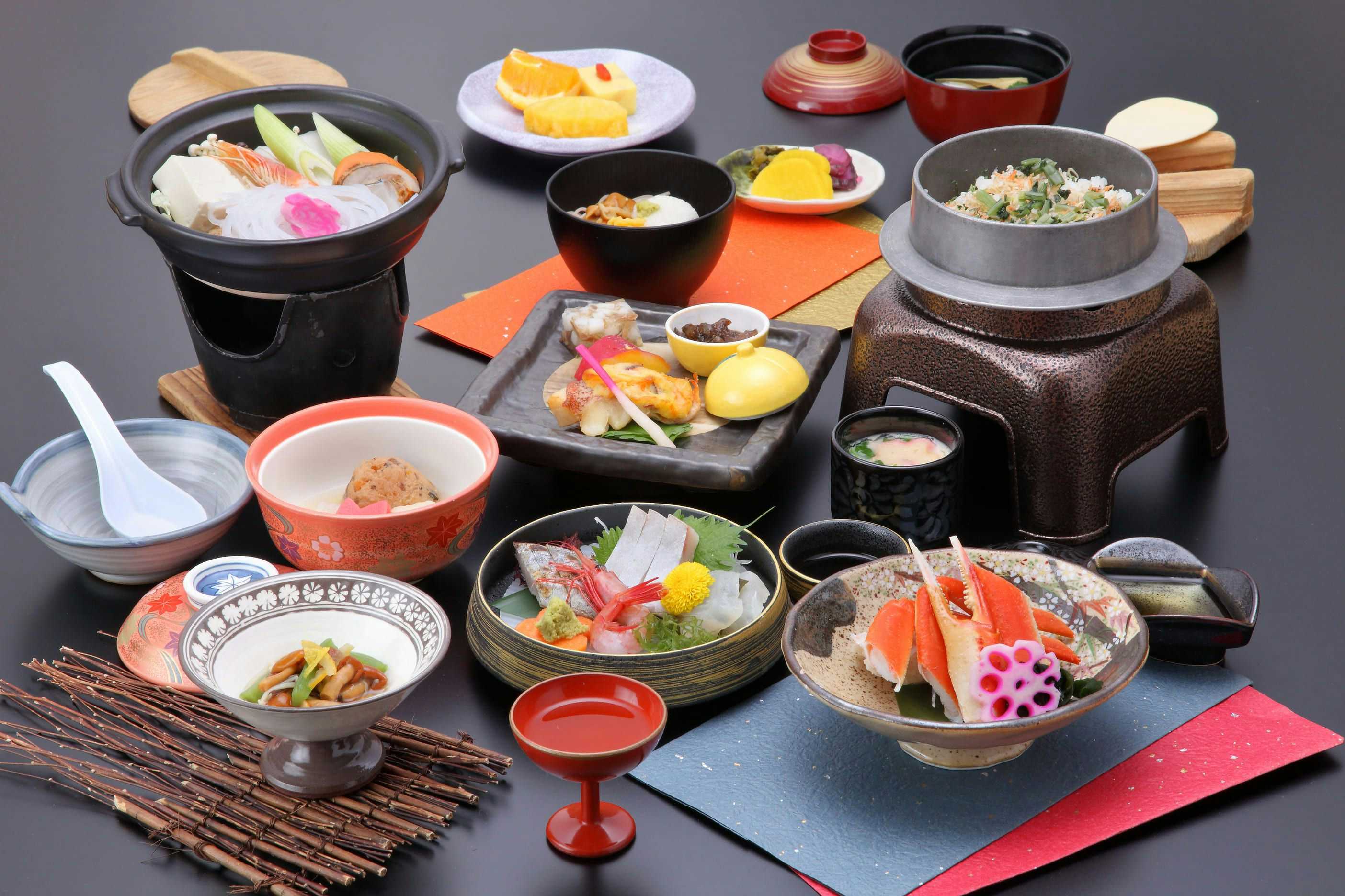 Wakura Onsen Housenkaku with a seafood dinner arranged around colorful bowls and plates.