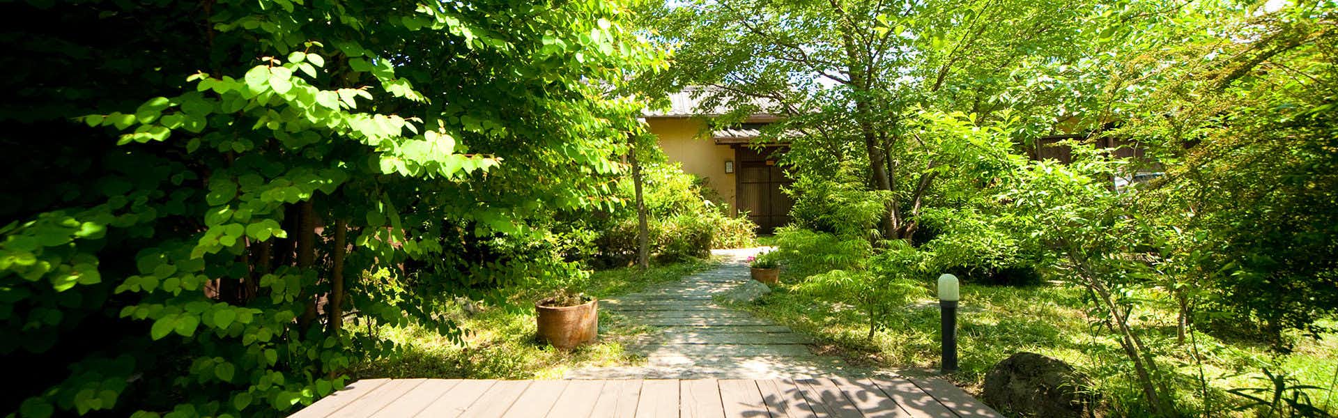 Onyado Yufunoshou garden path winding between leafy trees and guest buildings