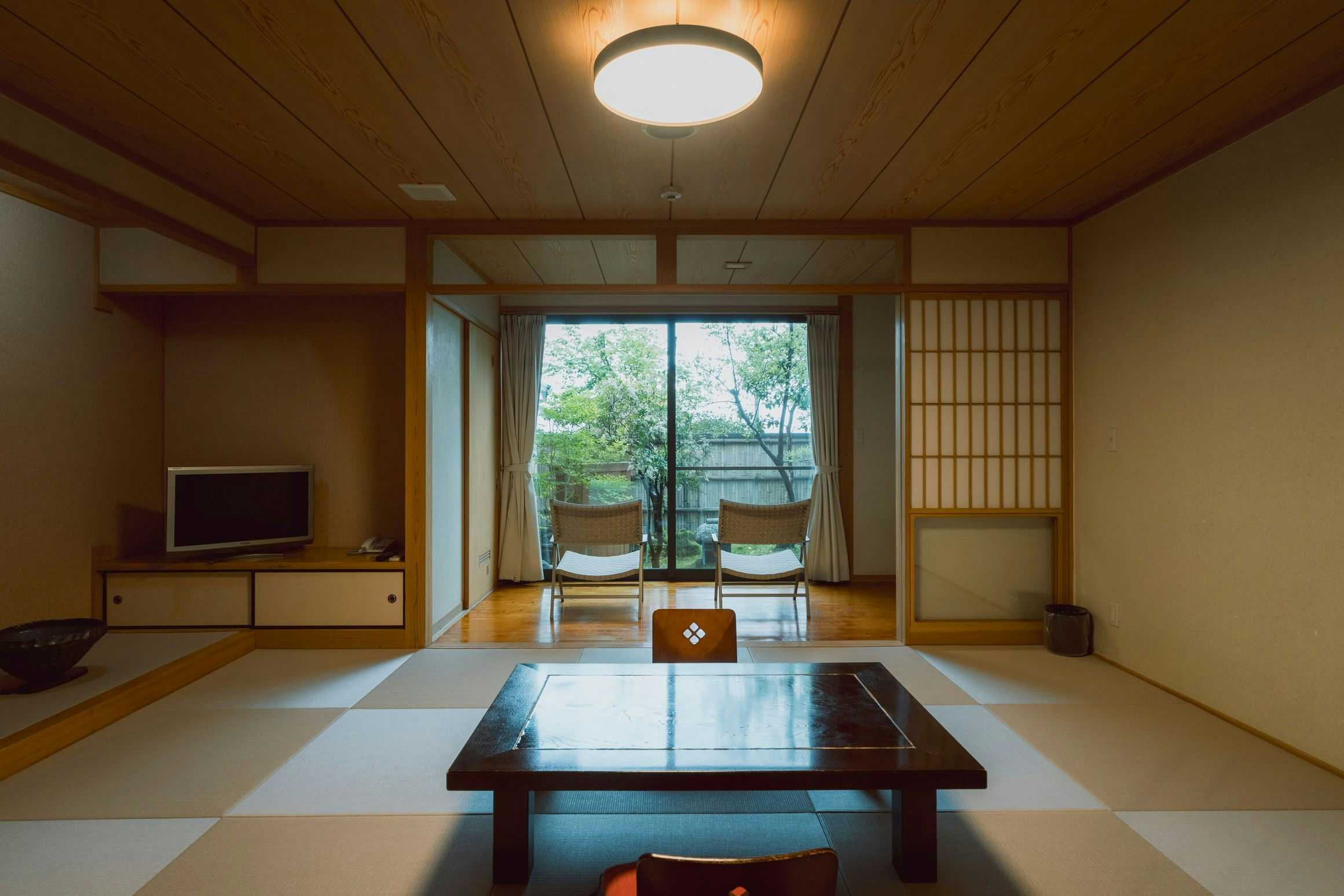 Hakusui Onsen Takenokura Sanso with a calm tatami guest room with low table and floor chairs.