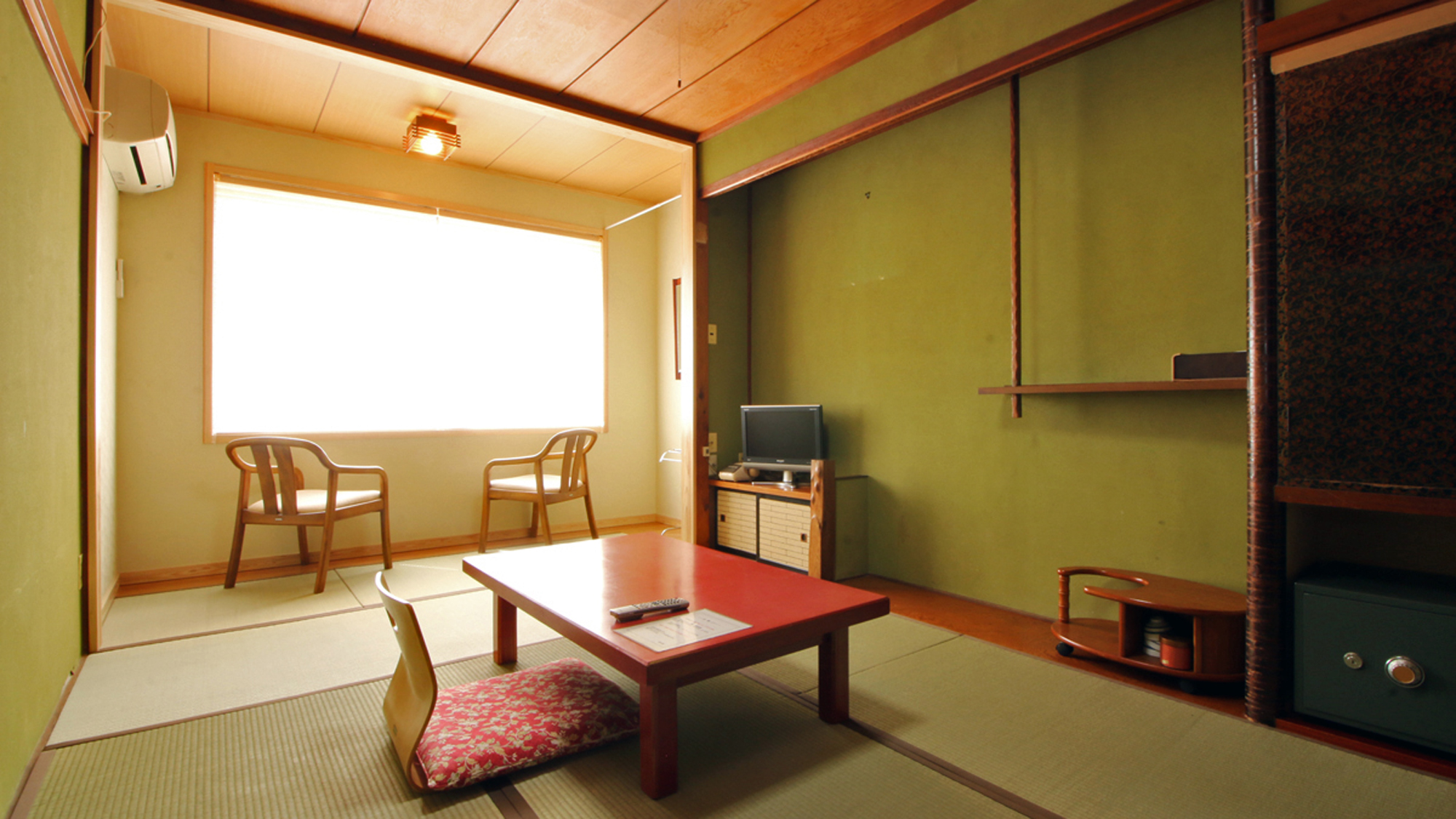 A tatami room with a low table and chairs by the window.