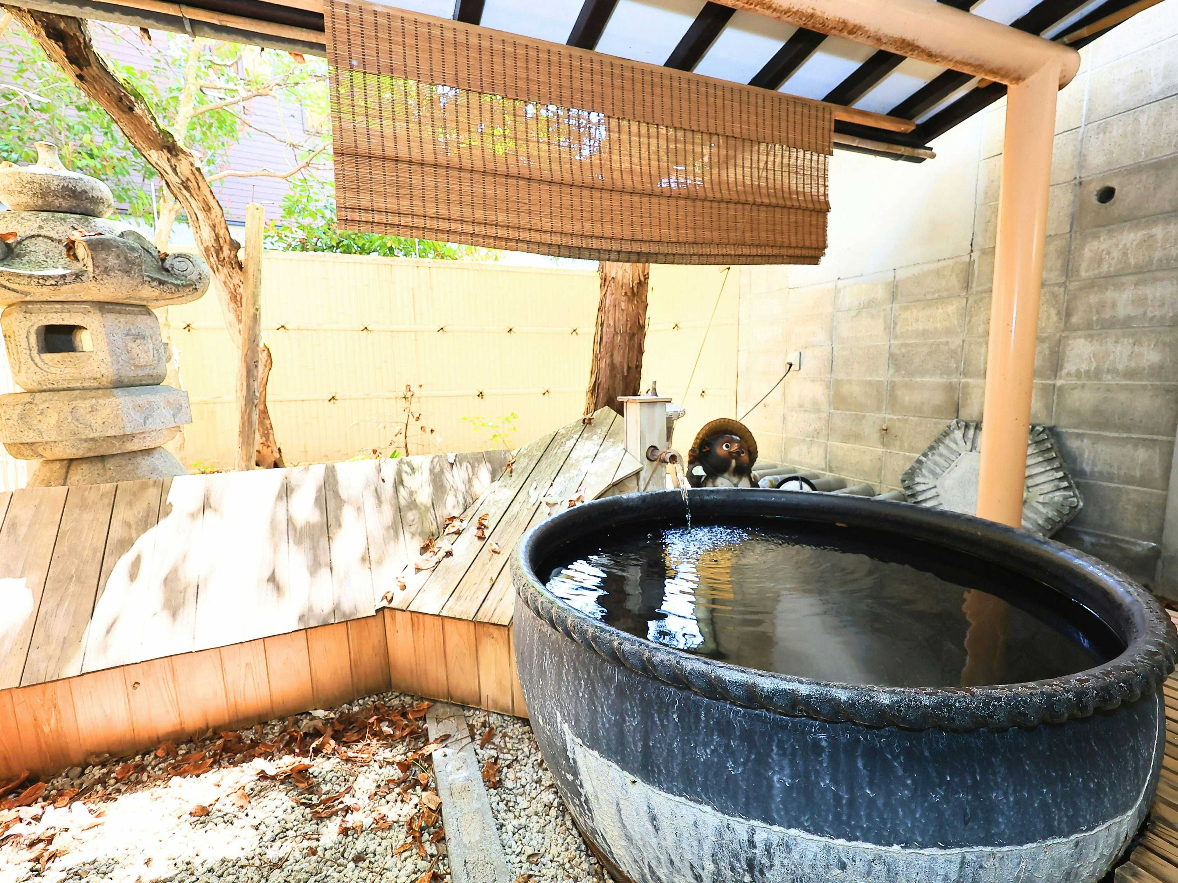 Oyado Hacihbei with a private round bath beneath a timber garden shelter.