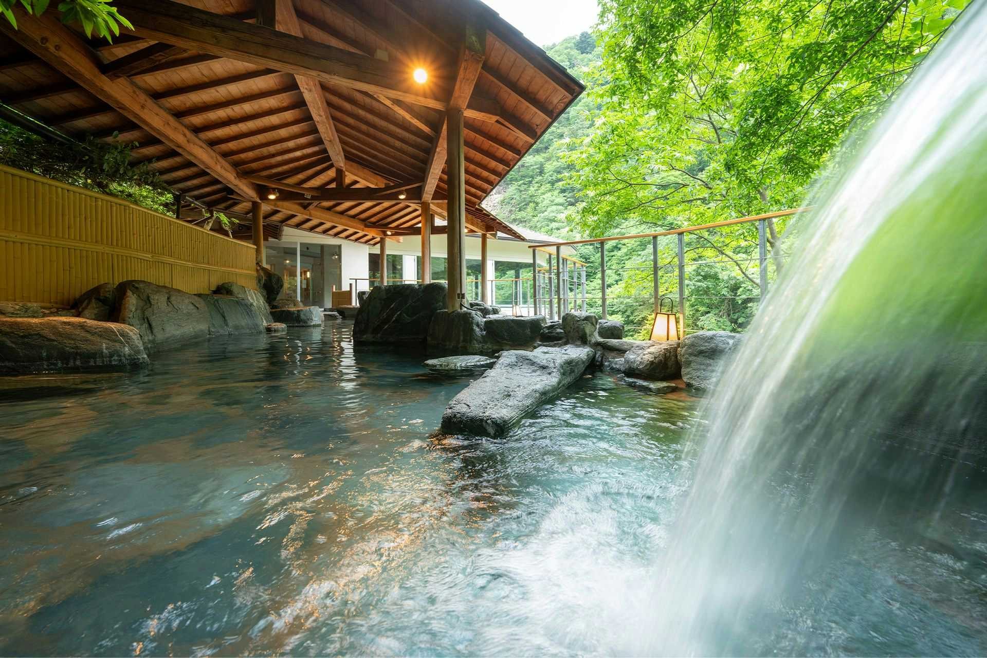 Takumi no Kokoro Yoshikawaya with an open-air bath fed by a broad cascade.
