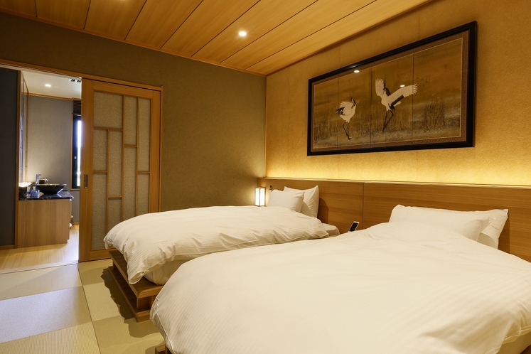 Twin beds beneath a wooden ceiling and framed artwork.