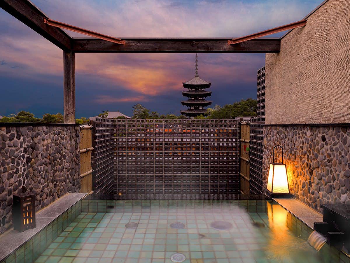 Asukasou Inn in the Ancient City of Nara with an open-air stone bath facing Kofukuji Pagoda at dusk.