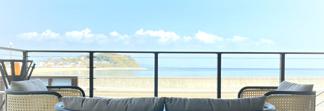 Cushioned terrace seating facing the sea and horizon.