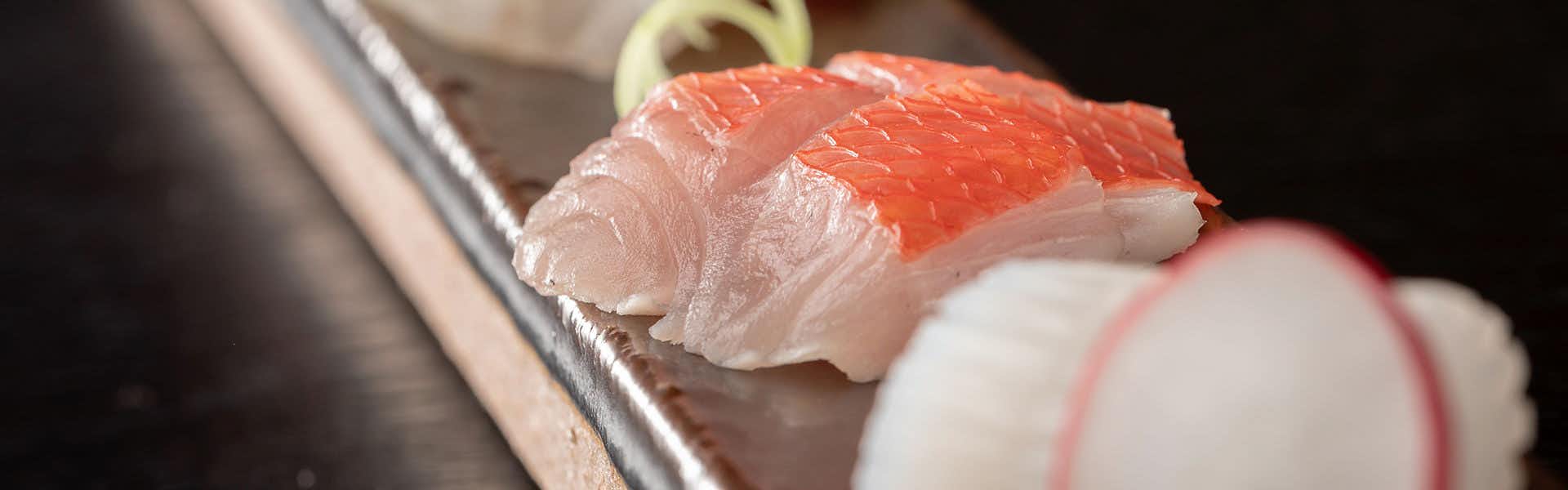 Izu Kawazu Onsenkyo Kaiyutei with red and white sashimi arranged on a dark plate.