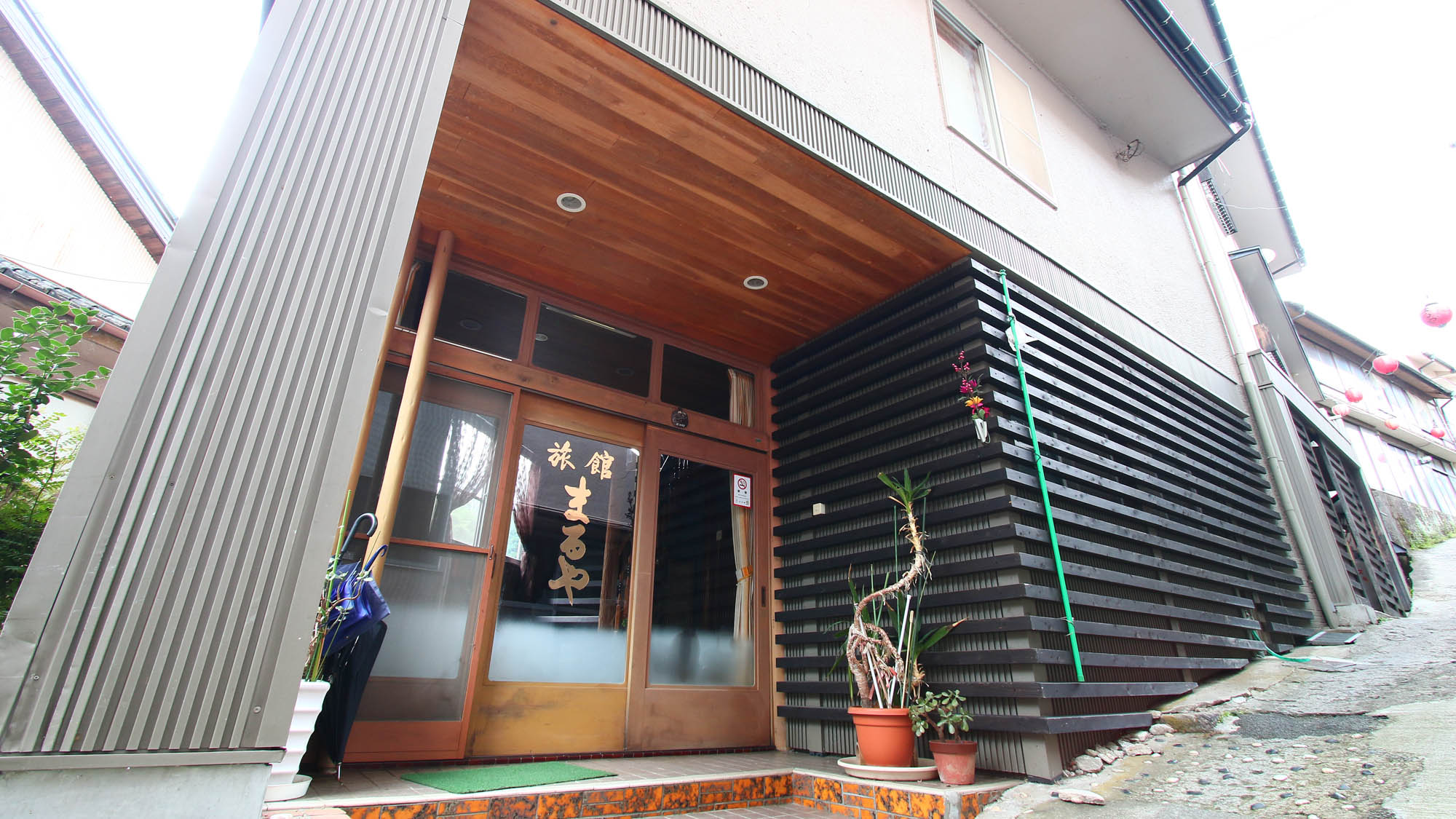 Ryokan Maruya with the ryokan entrance marked by a hanging lantern and timber sign.