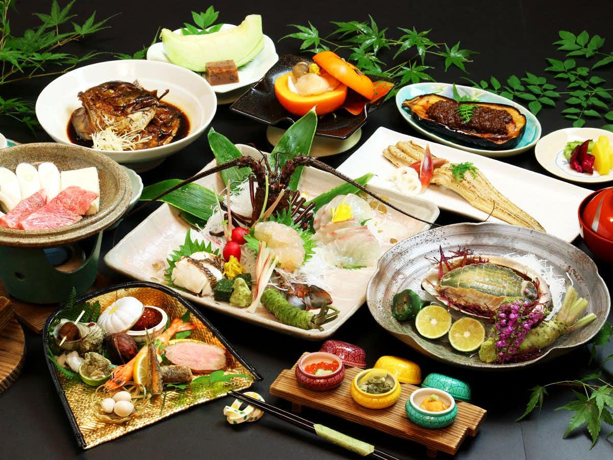Ryokan Restaurant Donryu with an abundant Japanese dinner featuring shellfish and grilled fish.