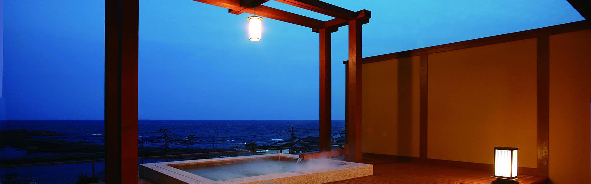 Houraiya Ryokan with a private bath framing the deep blue evening sea.
