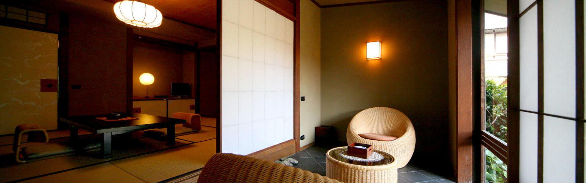 Yoyokaku Interior with woven basket chairs, wooden column, and decorative vessels on floor