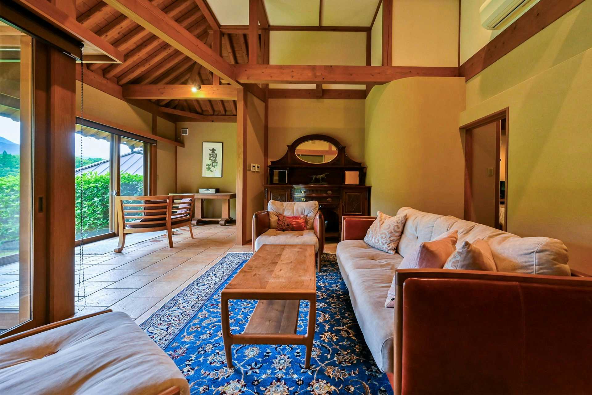 Yufuin Onsen Yutori no Yado Ikkoten with a timber lounge with sofas and open garden doors.