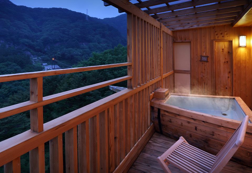 A wooden outdoor bath overlooking a valley.