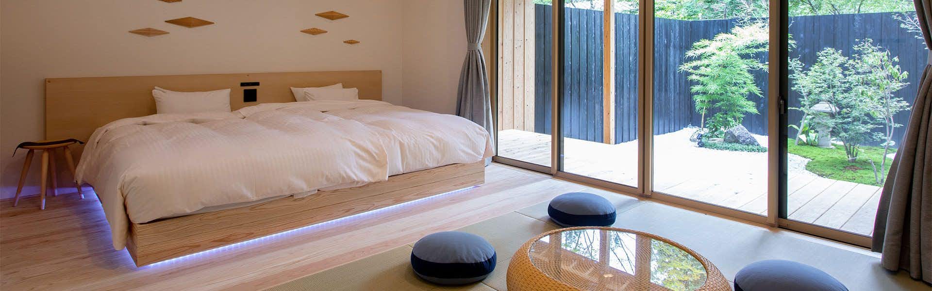 Shirakawa Onsen Kashoan a modern bedroom adjoining a tatami sitting area and garden.