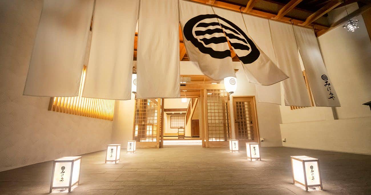 Izu Atagawa Onsen Miharuya with this scene, where a white noren marks Miharuya's warmly lit entrance, flanked by floor lanterns.