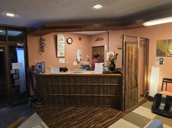 A wooden reception counter beneath framed decorations.