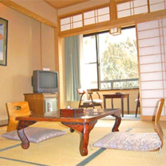 Hirayu Onsen Ryokan Tanaka with this scene, where a second tatami room pairs floor chairs with mountain-facing windows.