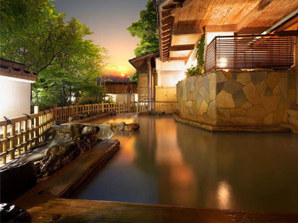 Moriaki Ryokan with an open-air bath beside a stone wall and flowing channel.