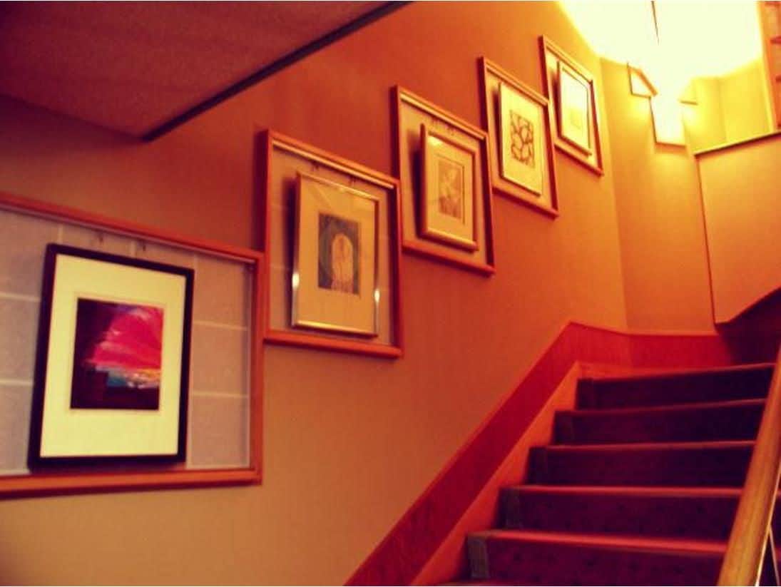 Tokiwokazaderu Yado Wakaba Ryokan with a warm stairway lined with framed artwork.