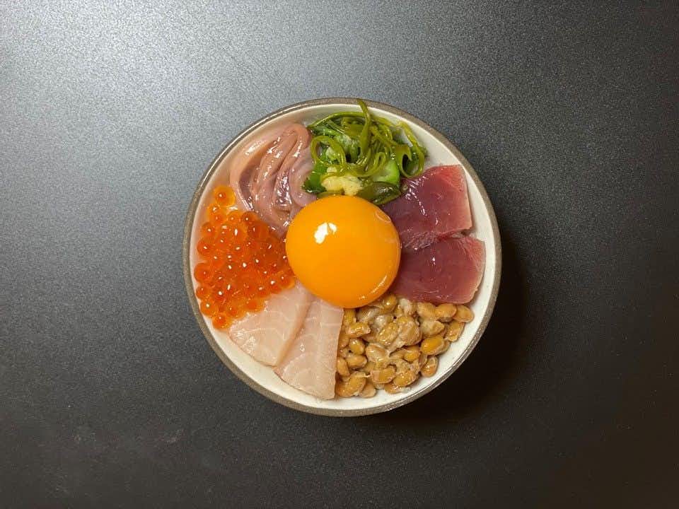 Amimoto no Yado Isomura with a seafood rice bowl topped with egg yolk and scallions.