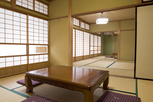 En no Yado Kitabori with a sunlit tatami room with low carved wooden table.