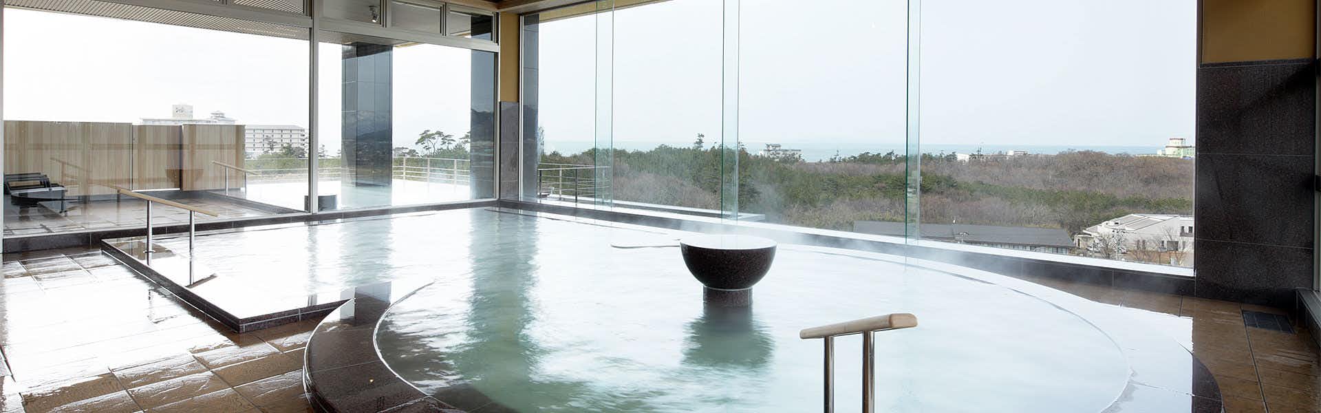 Senami Grand Hotel Haginoya with a spacious indoor mineral bath behind broad coastal windows.