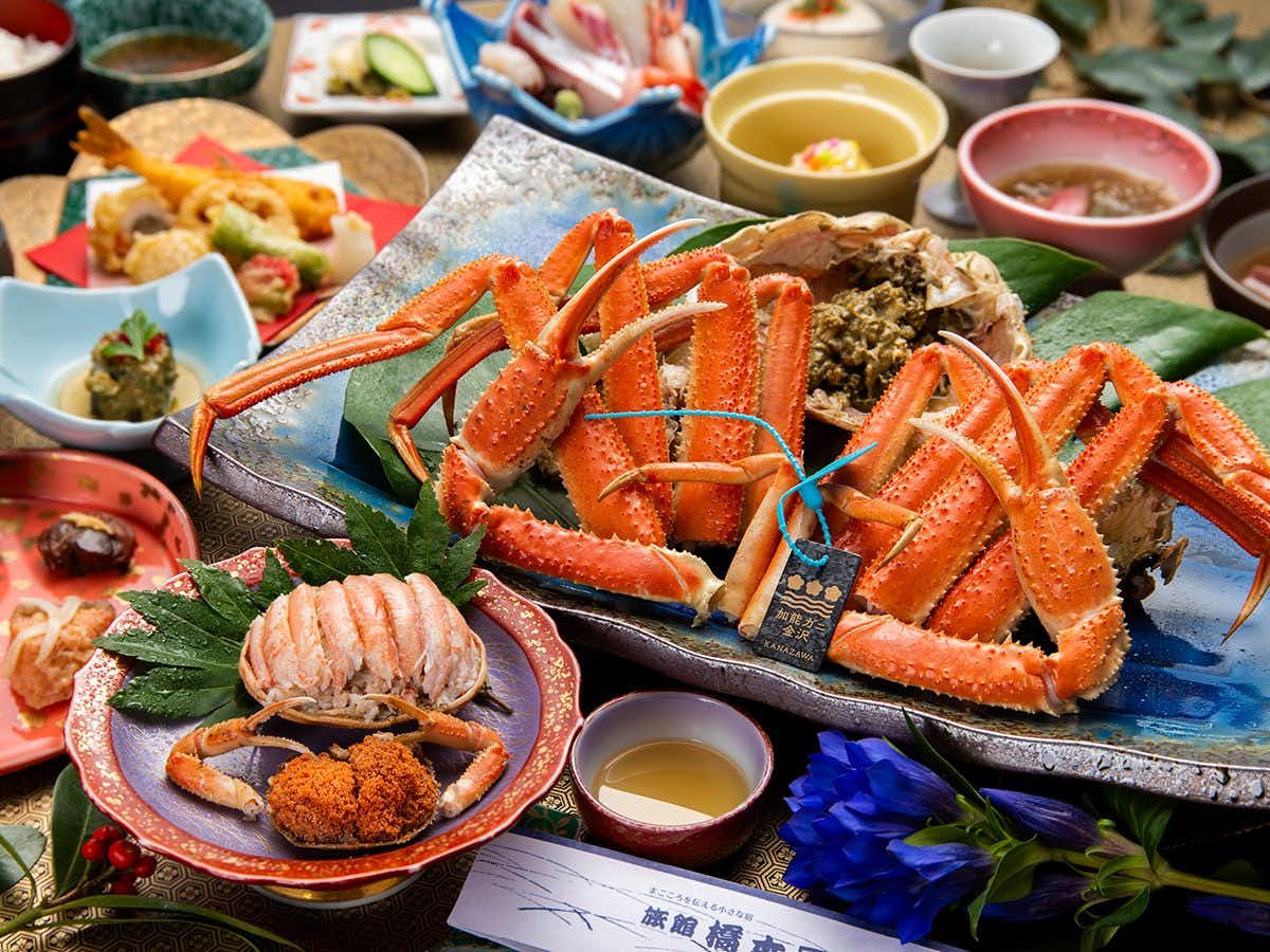 Ryokan Hashimotoya with a whole snow crab presented beside seasonal seafood dishes.