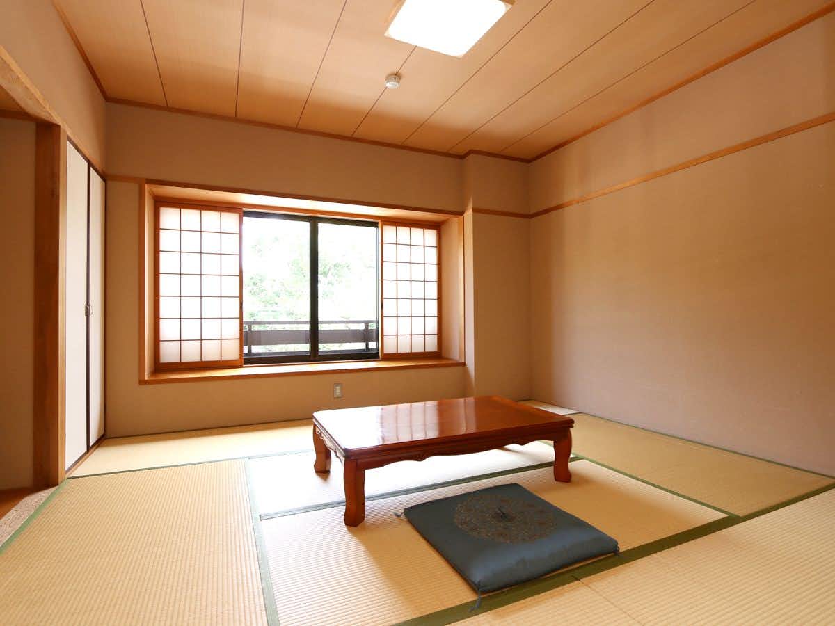 Ryokan Otorii-en with a bright tatami room with two low wooden tables.