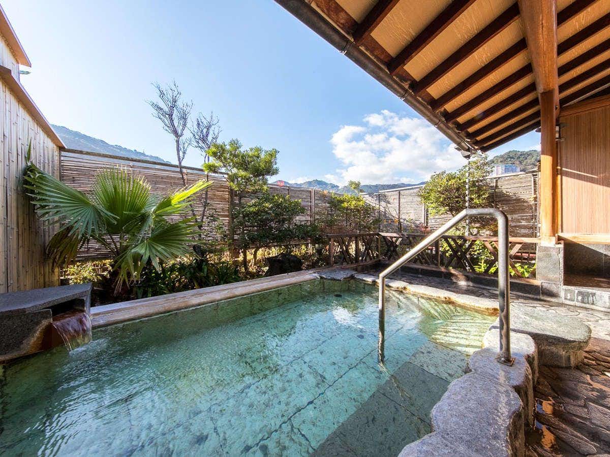 Ryokan Tachibana with an open-air bath overlooking the coastal town and blue water.