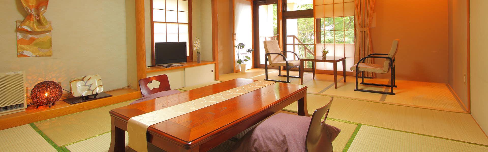 Hoshi no Akari (Nasu) with this scene, where its tatami guest room arranges armchairs and a long timber table beside garden windows.