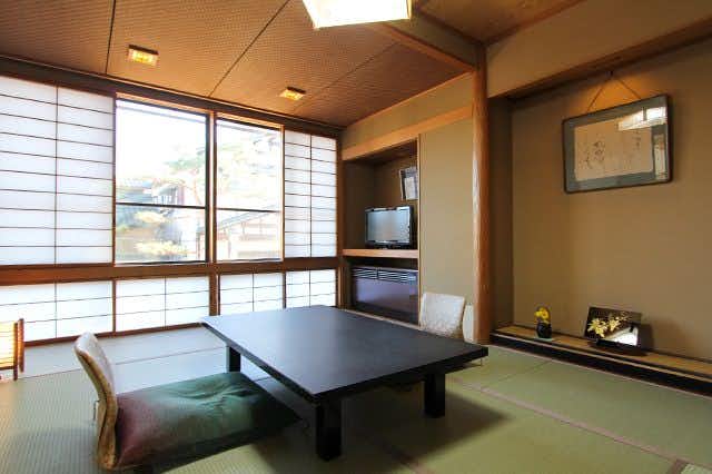 Tsukioka Onsen Yuasobi Yado Akebono tatami room with a low table, television and street-facing window