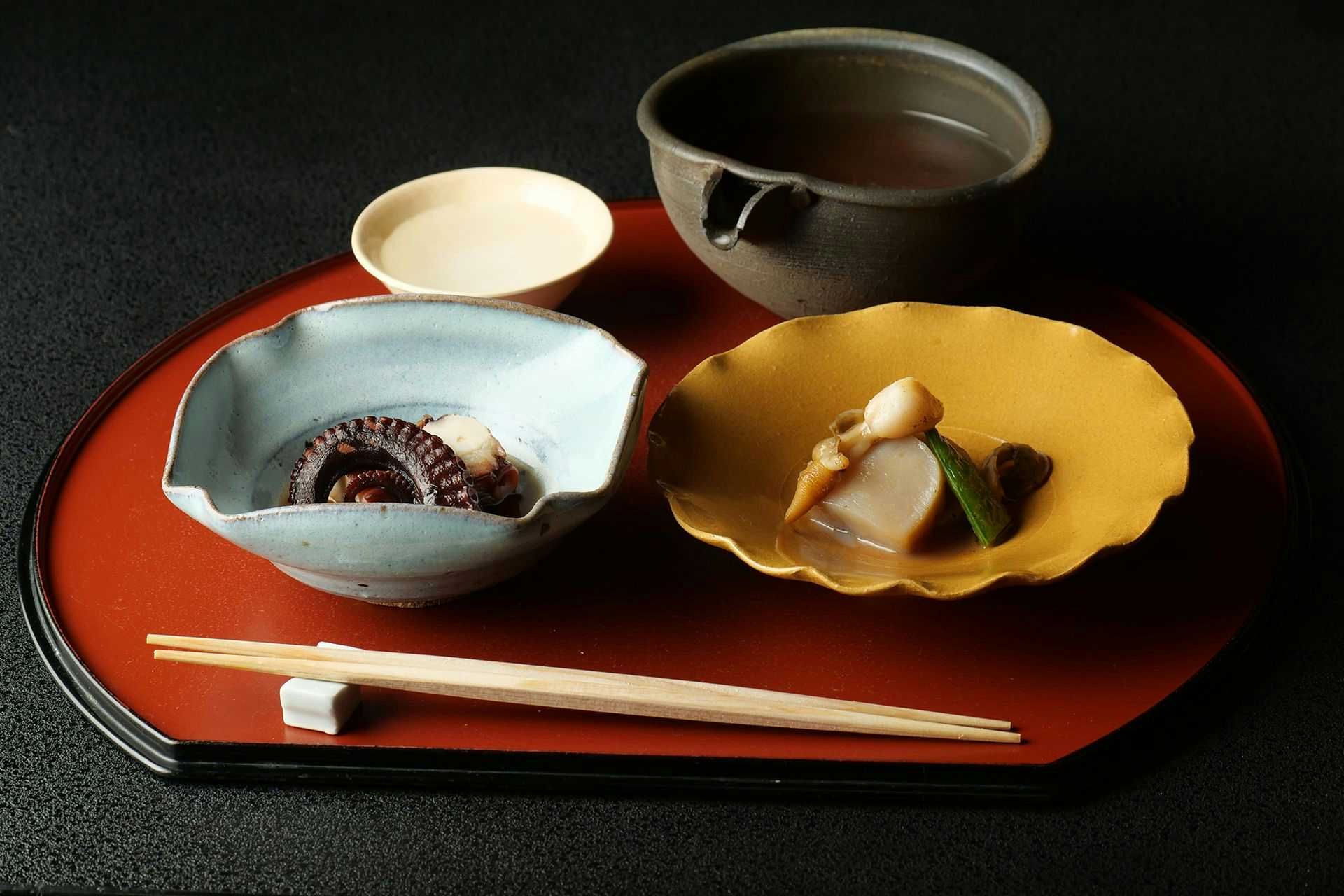Yoyokaku Red lacquer tray with white bowl, dark vessel, yellow dish, and wooden chopsticks