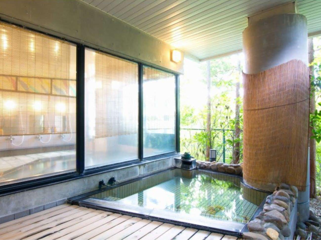 Morioka Tsunagi Onsen Tabizomeya Yamaichi with an indoor bath overlooking green trees.
