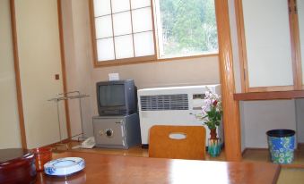 A sitting area with a table, television, and window.