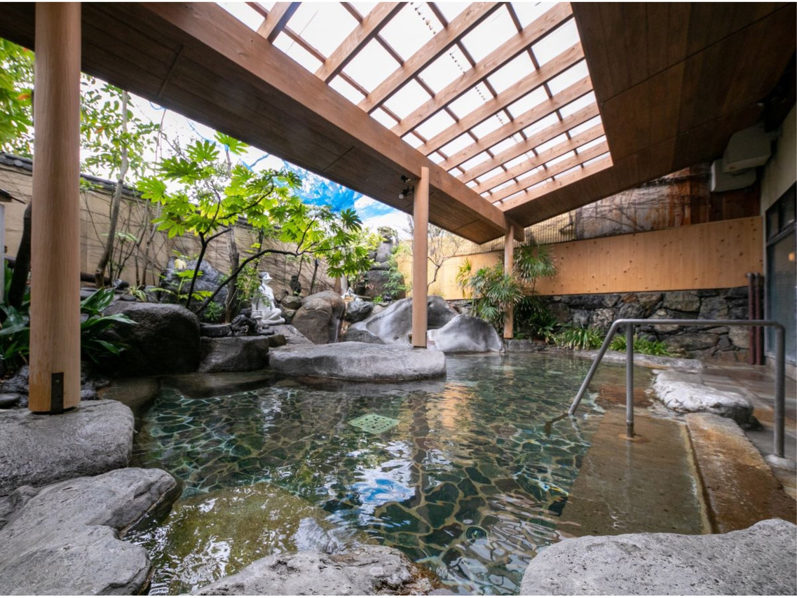 A covered outdoor bath with rocks.