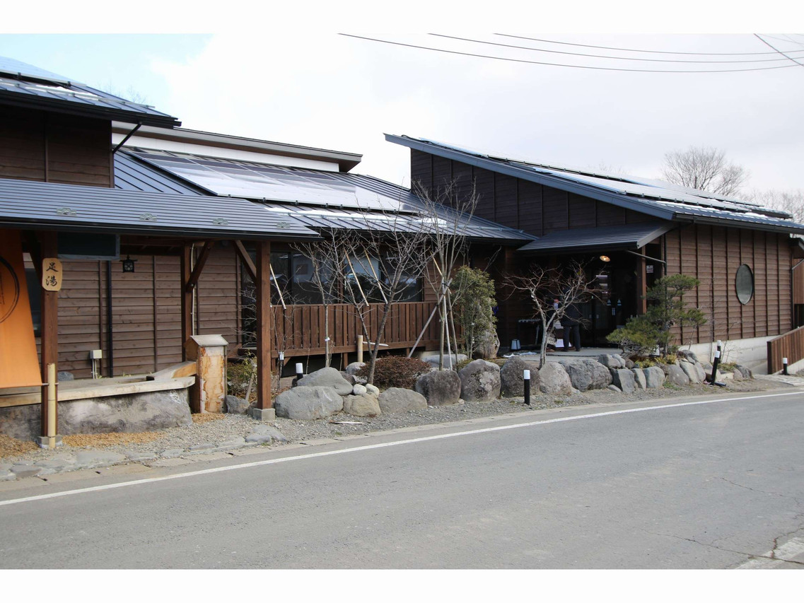 A ryokan building is surrounded by a quiet garden and rocks.