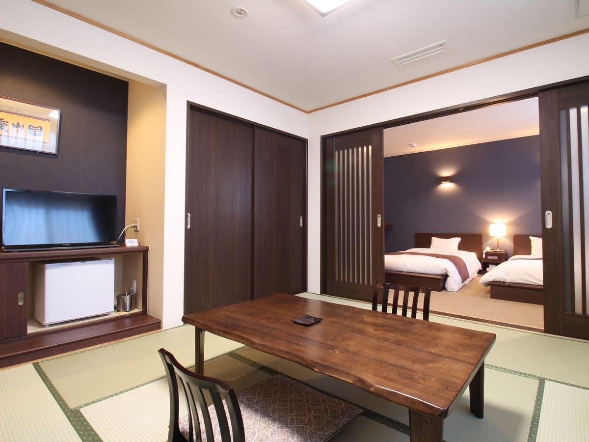 Ryokan Shiobetsu Tsurutsuru Onsen with a split-level guest suite with tatami seating and twin beds.