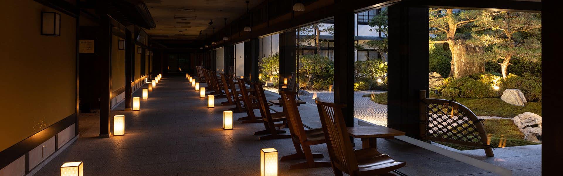 Hagi no Yado Tomoe with a lantern-lit corridor opening toward a landscaped garden.